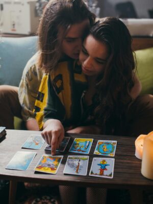 An intimate couple enjoying a tarot card reading together in a cozy indoor setting.