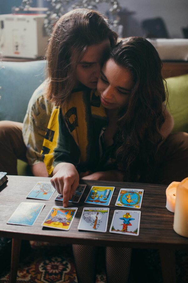 An intimate couple enjoying a tarot card reading together in a cozy indoor setting.