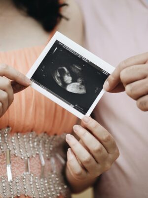 Close-up of a couple sharing an ultrasound photo, symbolizing pregnancy and family joy.